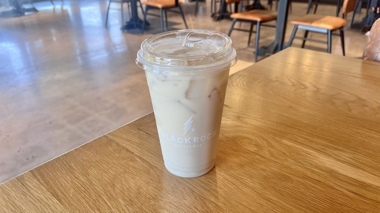 Black Rock Hot Chai with Banana on a table at a coffee bar served in a plastic cup