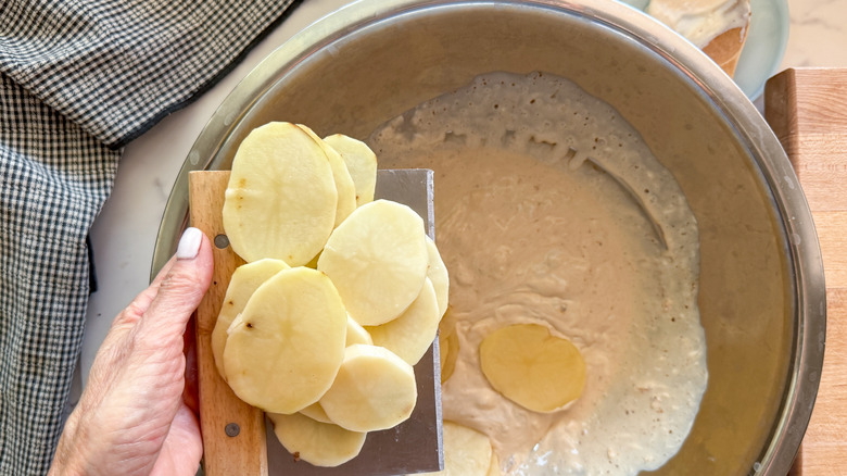 hand stirring creamy soup mixture in bowl