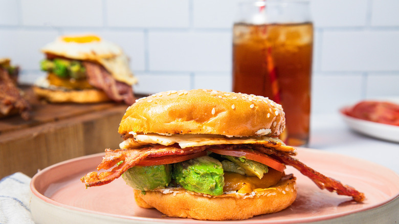 Sausage breakfast burger on plate with coke in background