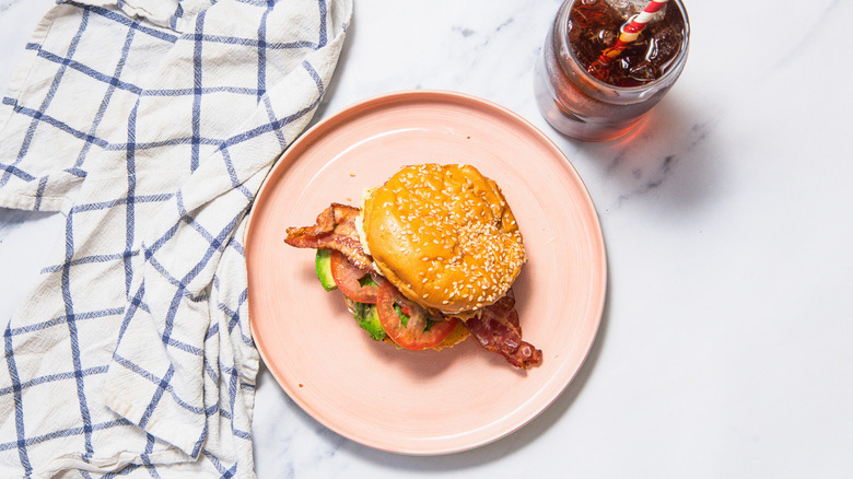 Sausage breakfast burger on plate with coke