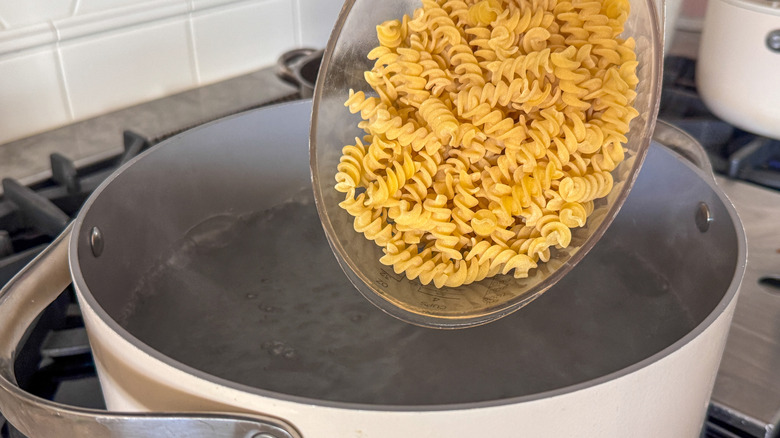 adding pasta to pot
