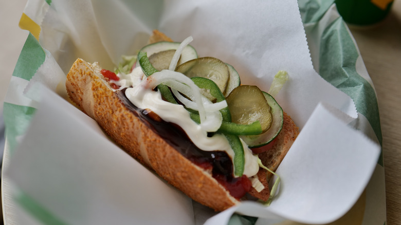 A subway sandwich with mayonnaise and barbeque sauce on it