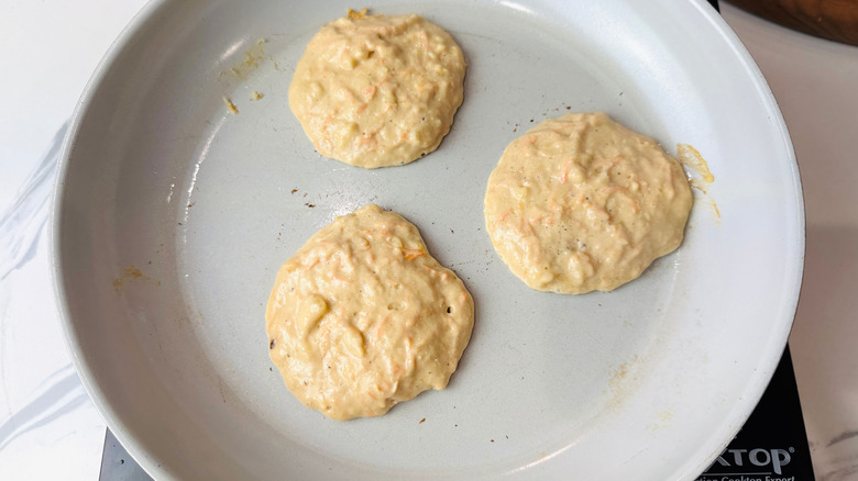 Uncooked carrot cake pancakes in pan