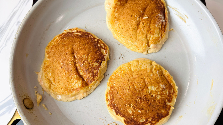 Browned pancakes in pan
