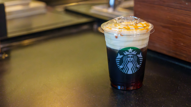 A Starbucks caramel-drizzled cold brew coffee on a counter.