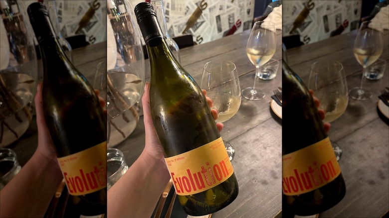 hand holding bottle of Sokol Blosser Evolution Lucky No. 9 White wine