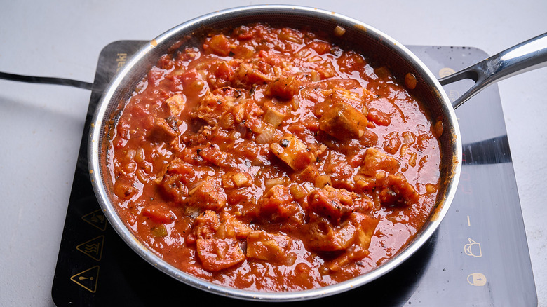 Tomato sauce with bread chunks in skillet