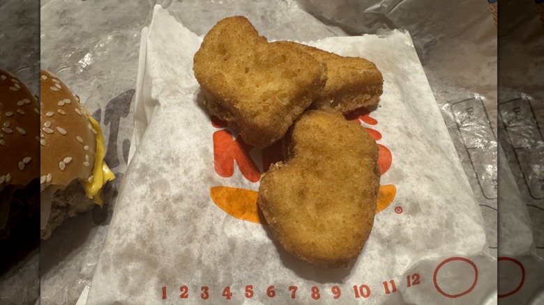 Three of Burger King's new chicken nuggets piled atop their paper bag