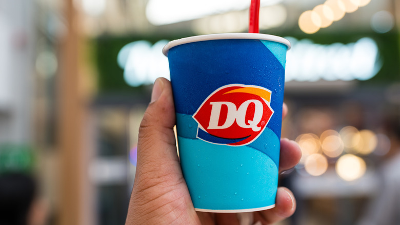 A hand holds a dairy queen cup with a spoon