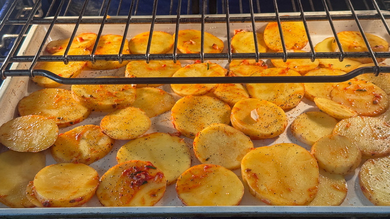 Sliced potatoes on sheet pan in oven