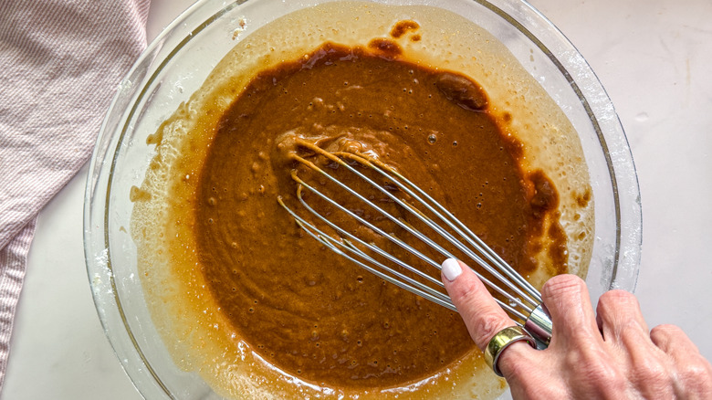hand adding butter to bowl