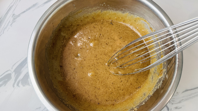Butter, brown sugar, and egg mixture with whisk in bowl
