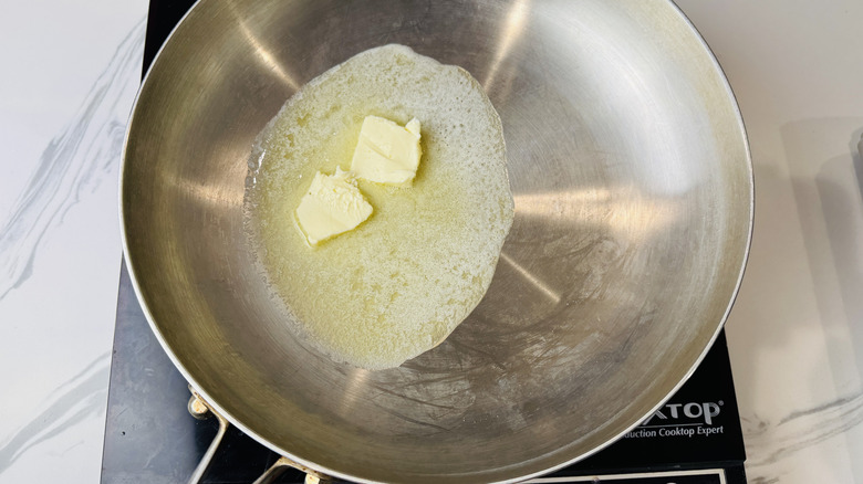 Pats of butter melting in skillet
