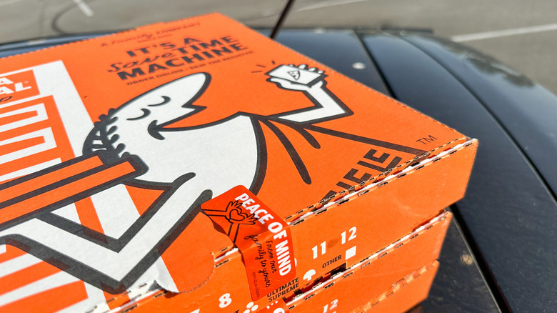 Little Caesars pizza boxes stacked on car