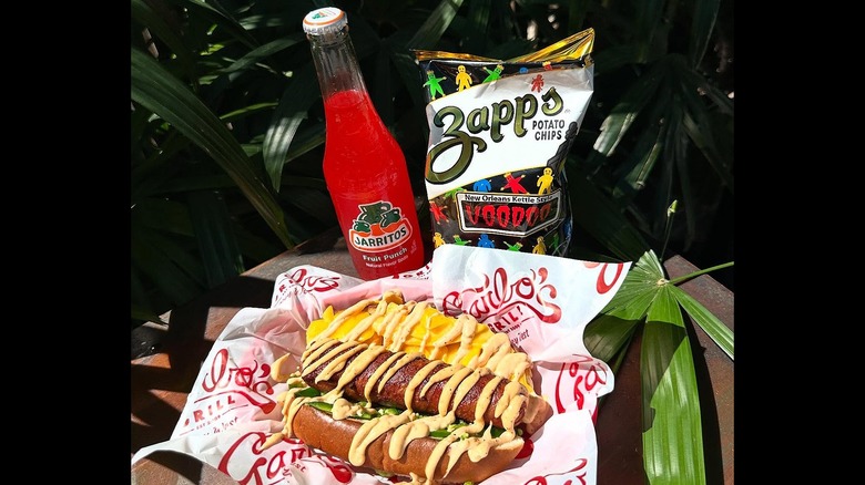 Hot dog in basket next to red Jarritos bottle and Zapp's chip bag