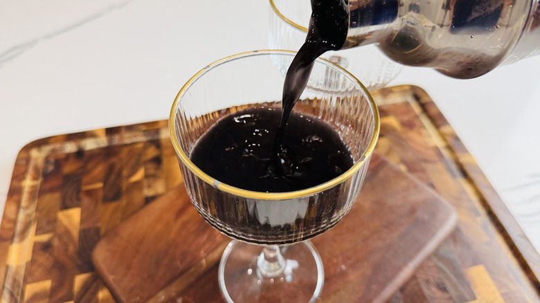 Cocktail straining from shaker into glass
