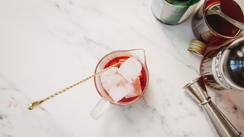 Mixing glass with gin and ice