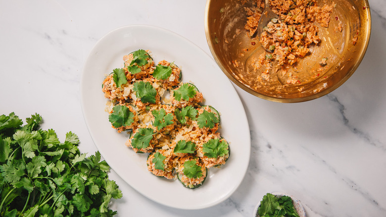 Plate of fricasse tuna salad bites alongside tuna salad bowl and cilantro