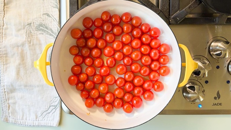 Cherry tomatoes and olive oil in large Dutch oven on stovetop