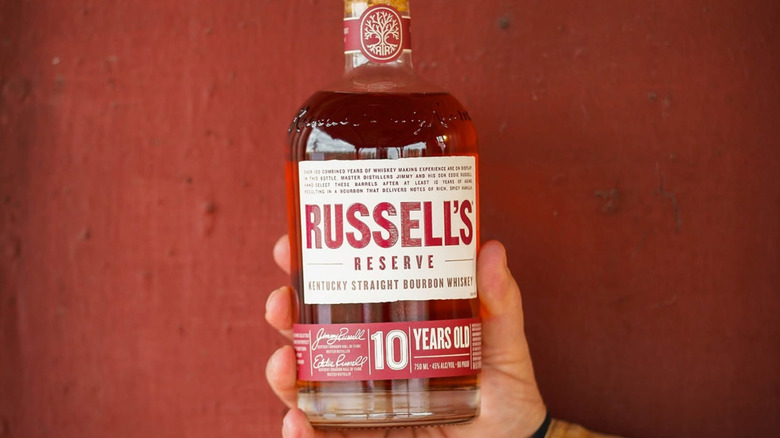 A person holding up a bottle of Russell's Reserve 10-year to the camera