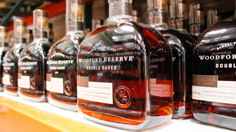 Several bottles of Woodford Reserve Double Oaked lined up on a liquor store shelf
