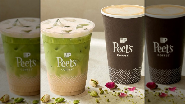 Peet's Coffee Pistachio Matcha Latte and Rose Pistachio Latte in cups on pale surface next to pistachios and rose petals