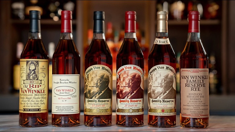 A row of six bottles of Pappy Van Winkle on a countertop with a blurred bar shown behind