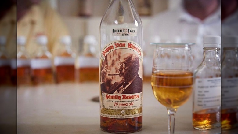 A close-up on a bottle of Pappy Van Winkle 20-year next to a filled glass