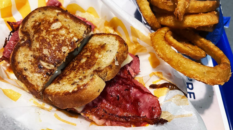 A Reuben melt and onion rings from Culver's on a tray
