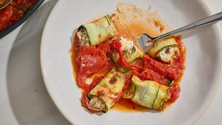 zucchini involtini in a bowl with a fork