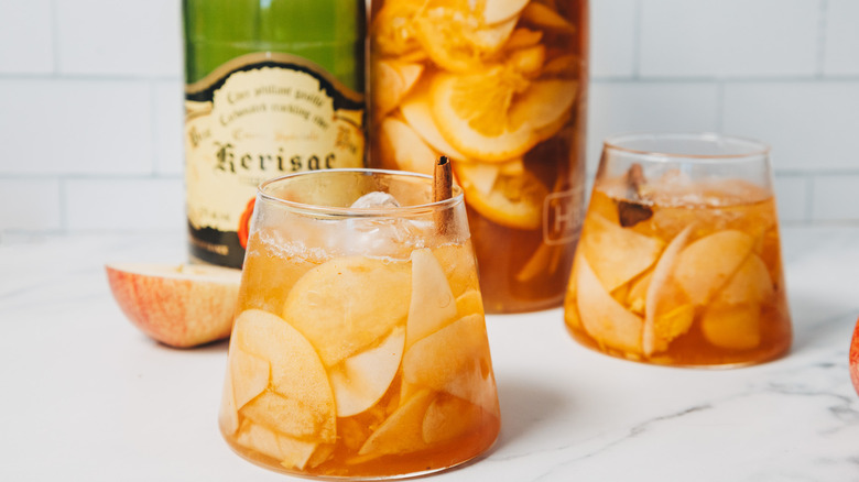 Two glasses of of apple sangria beside apple