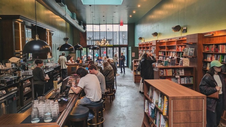 People browsing bookshelves and reading at bar