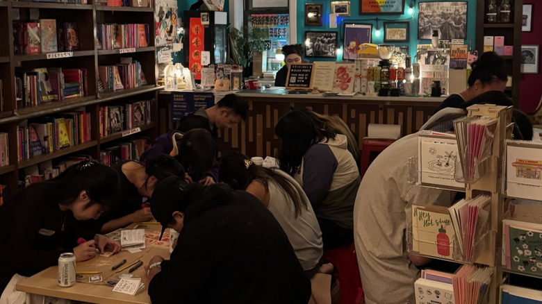 Customers participating in a block printing workshop in bookstore with coffee bar