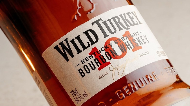 A close up shot of the label of a bottle of Wild Turkey 101 with a plain background