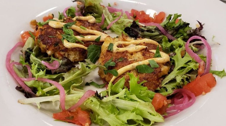 Two crab cakes on salad