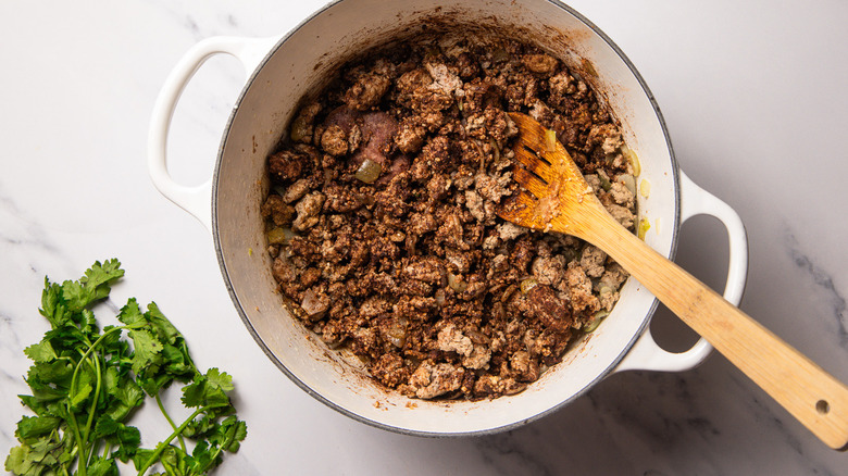 Stirring cooked turkey in Dutch oven