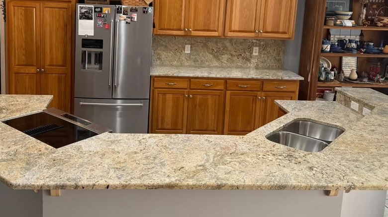 A kitchen with Colonial Cream granite countertops and warm oak cabinets